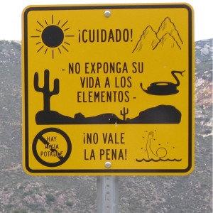 A border patrol sign warning, "Caution! Do not expose your life to the elements. It's not worth it!"