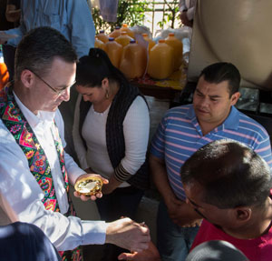 Jesuit Father Sean Carroll distributes communion to migrants at the Kino Border Initiative comedor in Nogales, Sonora, Mexico.