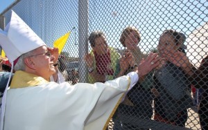 Bishop Seitz greets people on the Mexican side of the US-Mexico border during a bi-national mass in November 2014. [SOURCE: Catholic Herald]